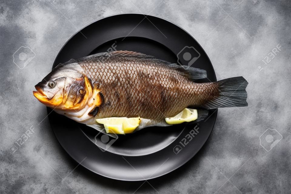 Red tilapia apply salt grilled fish on white dish 