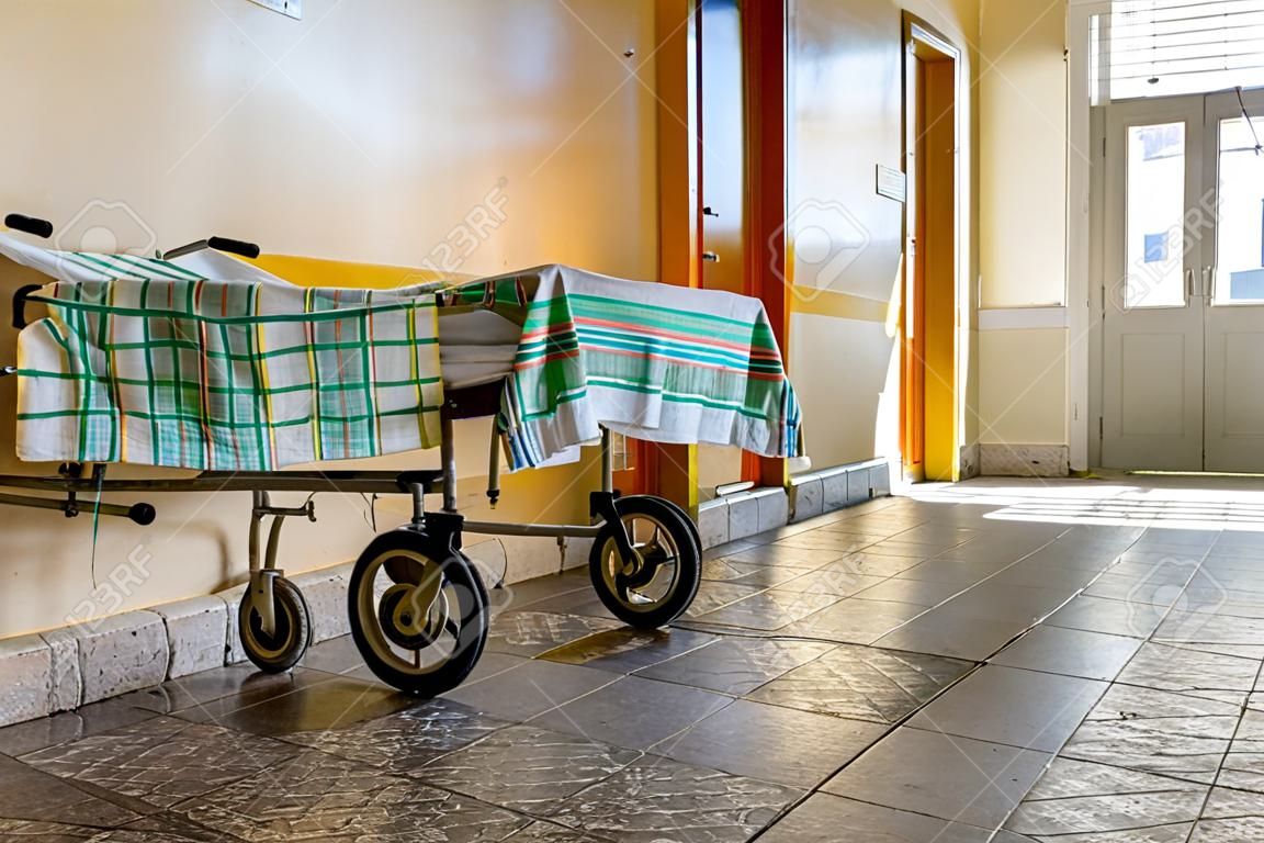 Cadeira de rodas esperar por visitantes e pessoas doentes no corredor do hospital da cidade. Cadeira de rodas como símbolo da última maneira. Hospital social para o homem pobre. Interior do antigo hospital municipal da cidade.