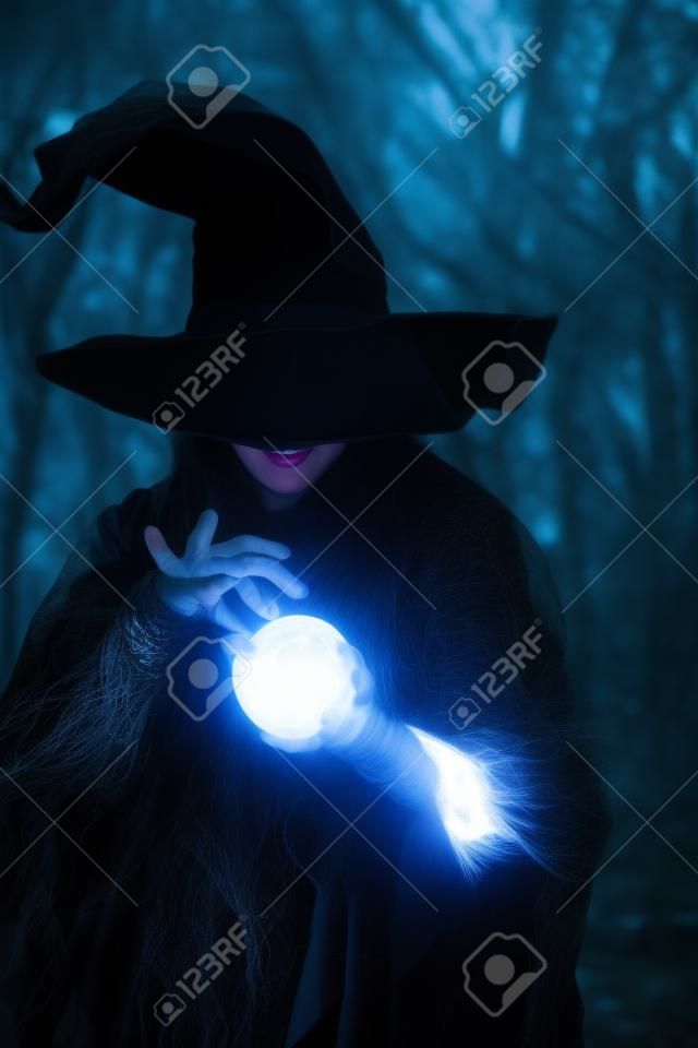 Photo of witch with glowing magic ball