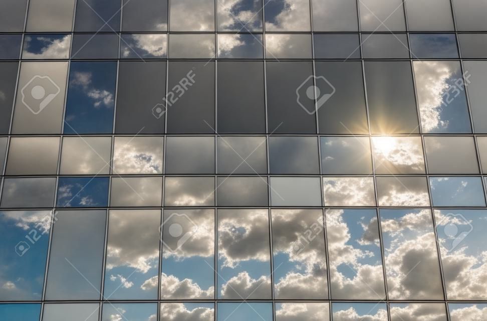 Reflexión de la nube y el sol en edificio de cristal