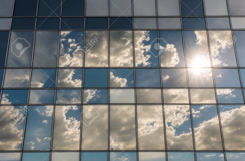 Reflexión de la nube y el sol en edificio de cristal