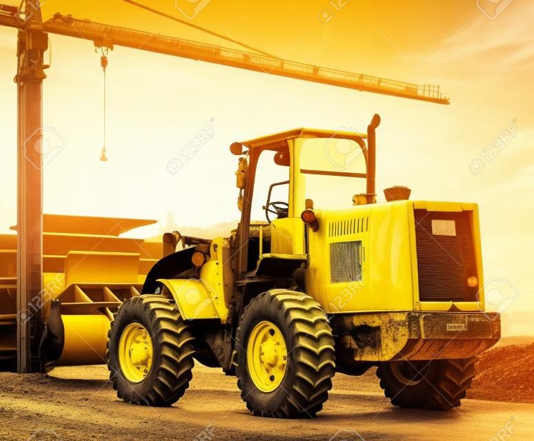 yellow tractor on the road at construction site