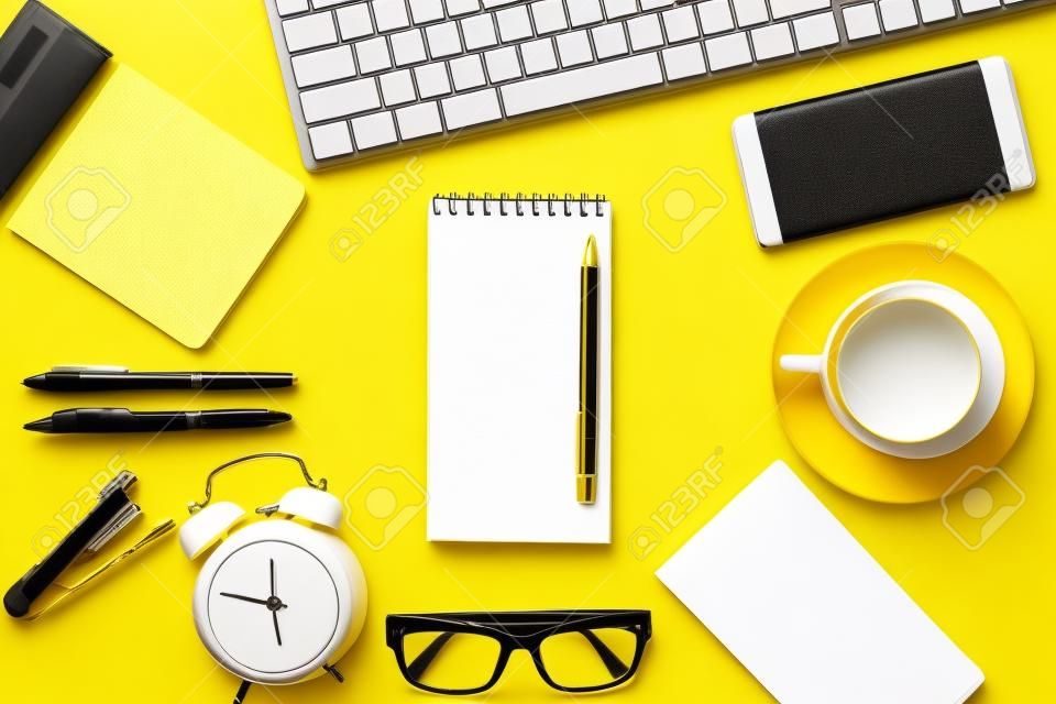 Blanco wit notitieblok met kantoor- en persoonlijke accessoires geïsoleerd op gele achtergrond, zakelijke motivatie en inspiratieconcepten.