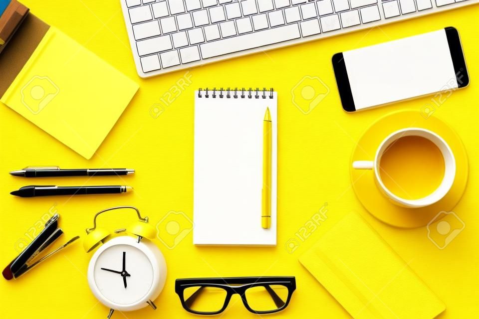 Blank white notepad with office and personal accessories isolated on yellow background, Business motivation and inspiration concepts.