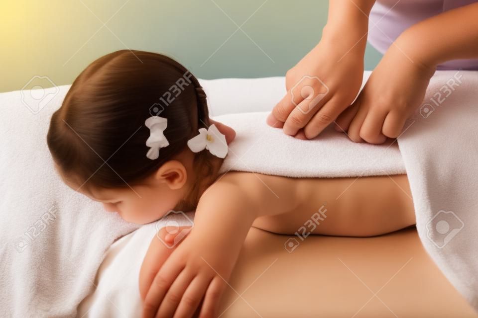 woman doing massage to a little girl. Wellness massage for scoliosis