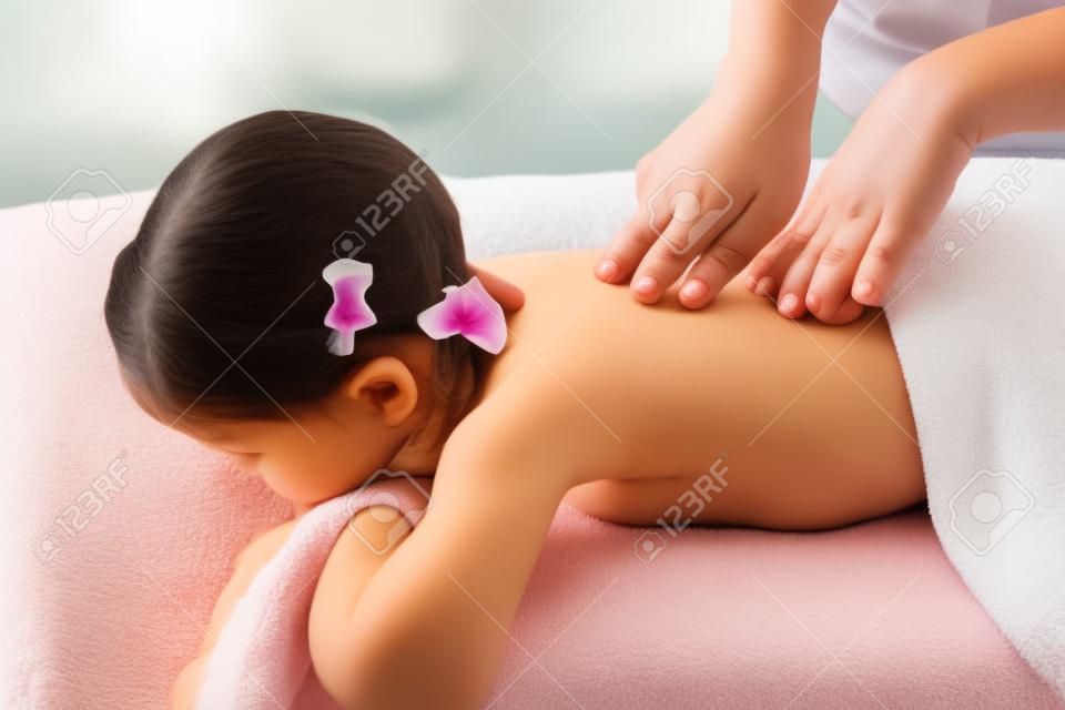 woman doing massage to a little girl. Wellness massage for scoliosis