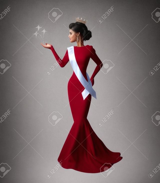 elegante silueta de una mujer hermosa en una corona, una cinta de suéter y un vestido largo en un concurso de belleza