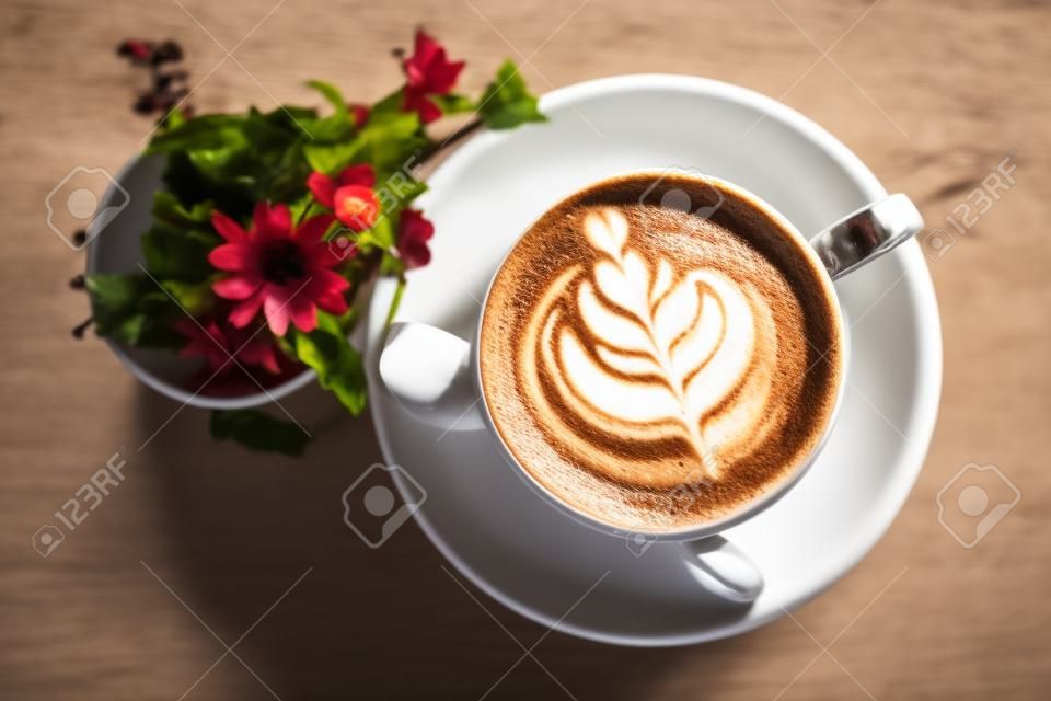 heißes latte-kaffeegetränk, das im café auf den tisch gelegt wird