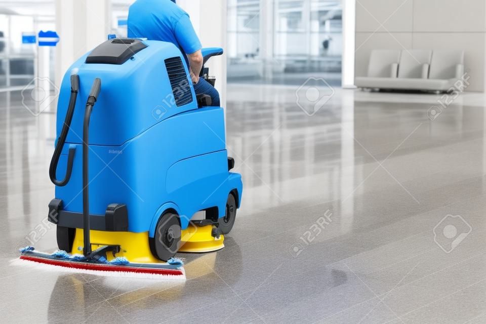 Mann fährt professionelle Bodenreinigungsmaschine am Flughafen oder Bahnhof oder Supermarkt. Bodenpflege und Reinigungsservice
