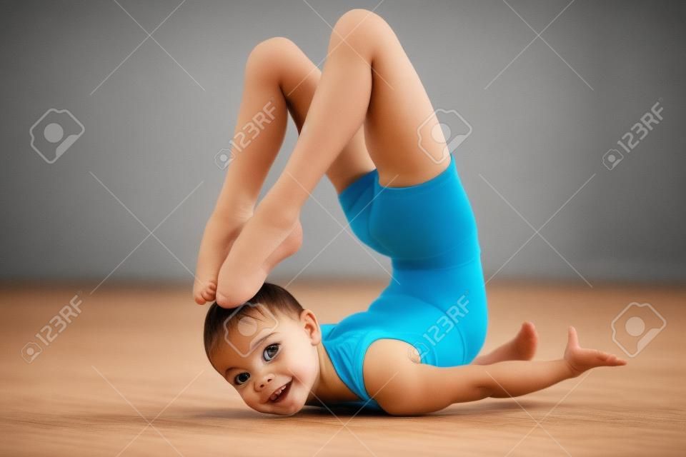 Bambino flessibile, bella bambina ginnasta facendo esercizi di ginnastica o esercitando in classe fitness