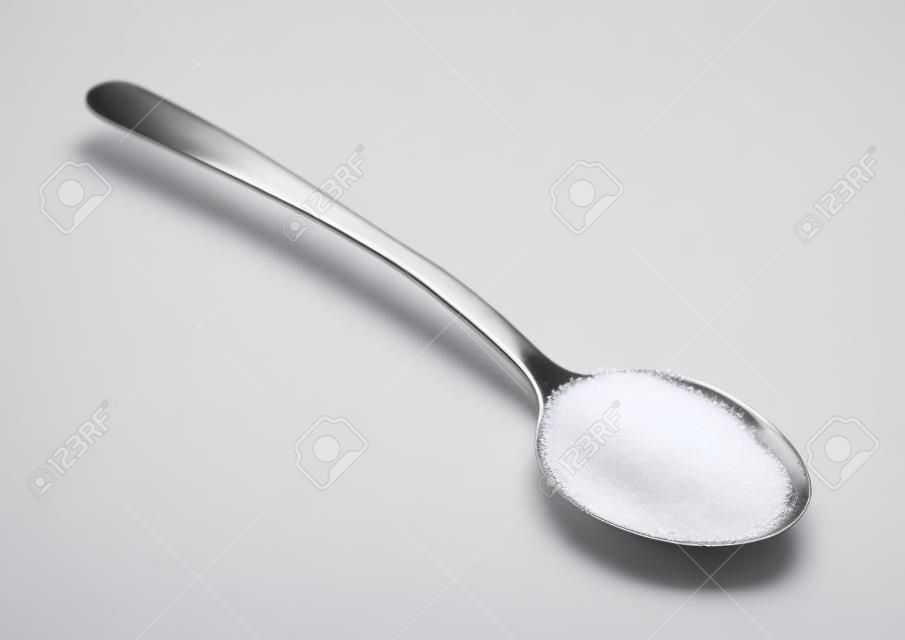 Teelöffel Zucker isoliert auf weißem Hintergrund