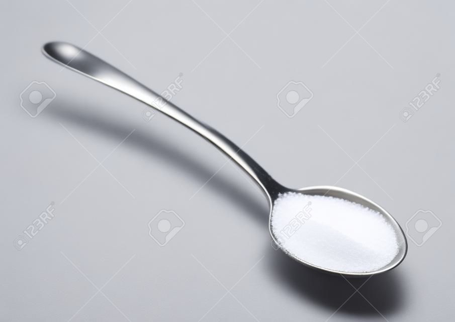 Cuillère à café de sucre isolé sur fond blanc
