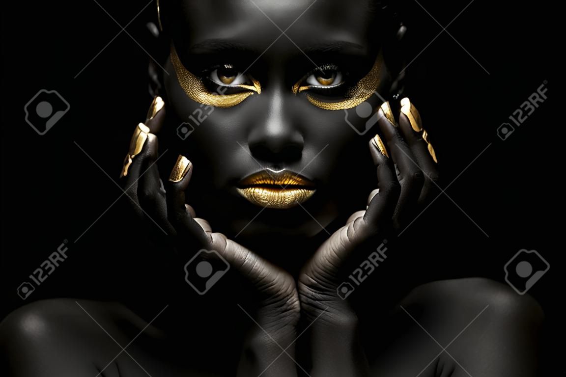 Fondo negro y mujer negra con elegante maquillaje dorado.