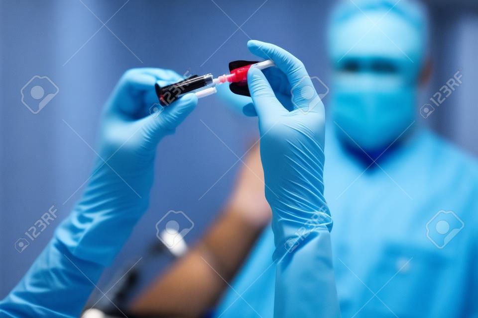 Phlebotomist assembling the syringe prior to blood collection