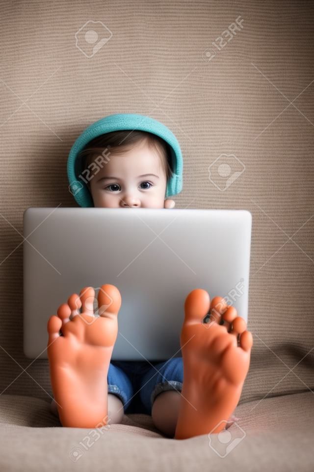 Feet of little girl using laptop