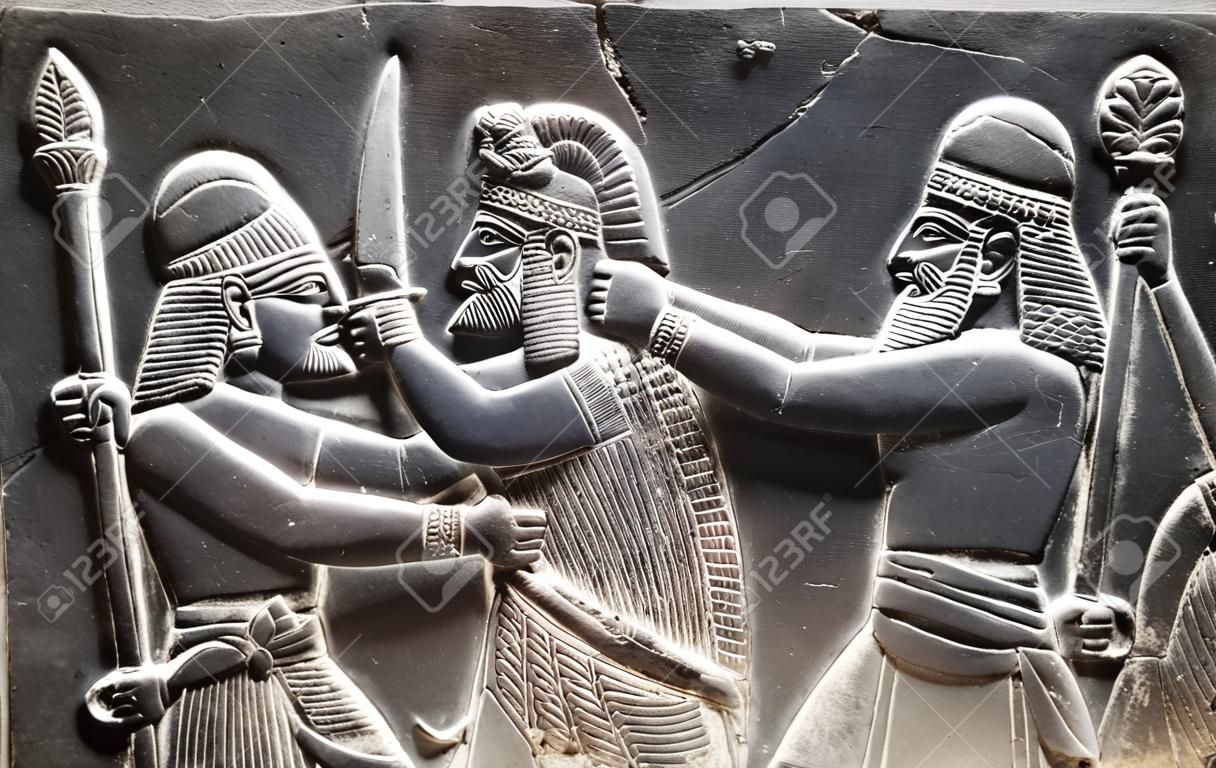 Entalhes de parede assírios antigos (guerreiros com arma)