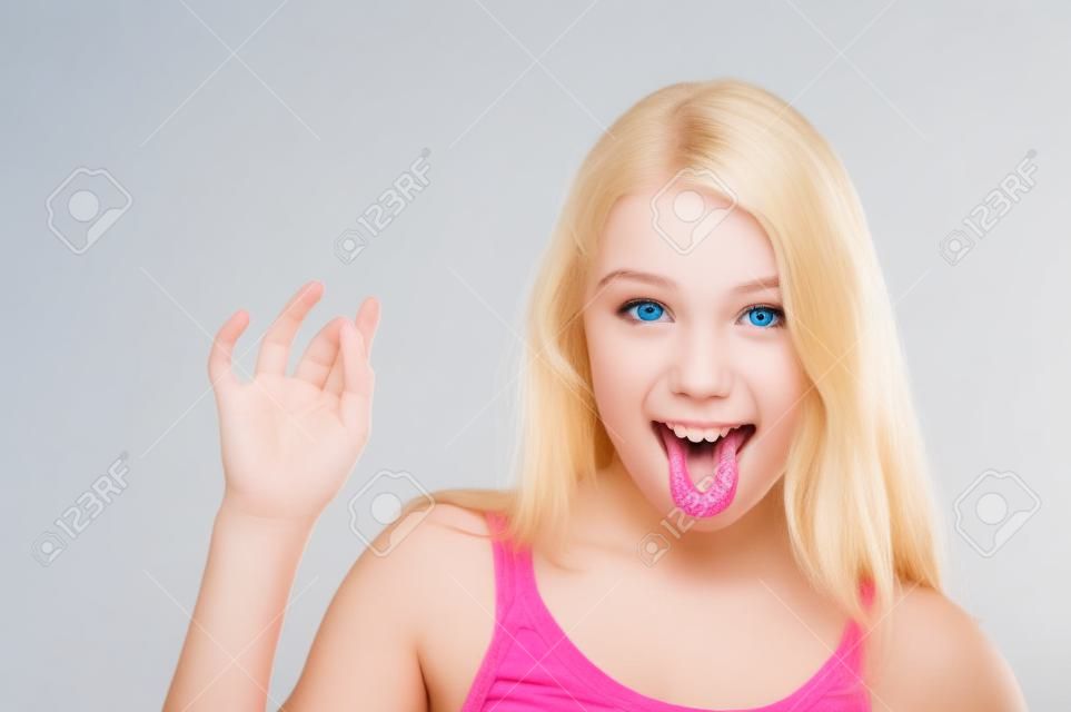 chica de adolescente rubia mostrando la lengua, aislado en blanco