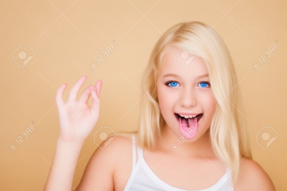 chica de adolescente rubia mostrando la lengua, aislado en blanco