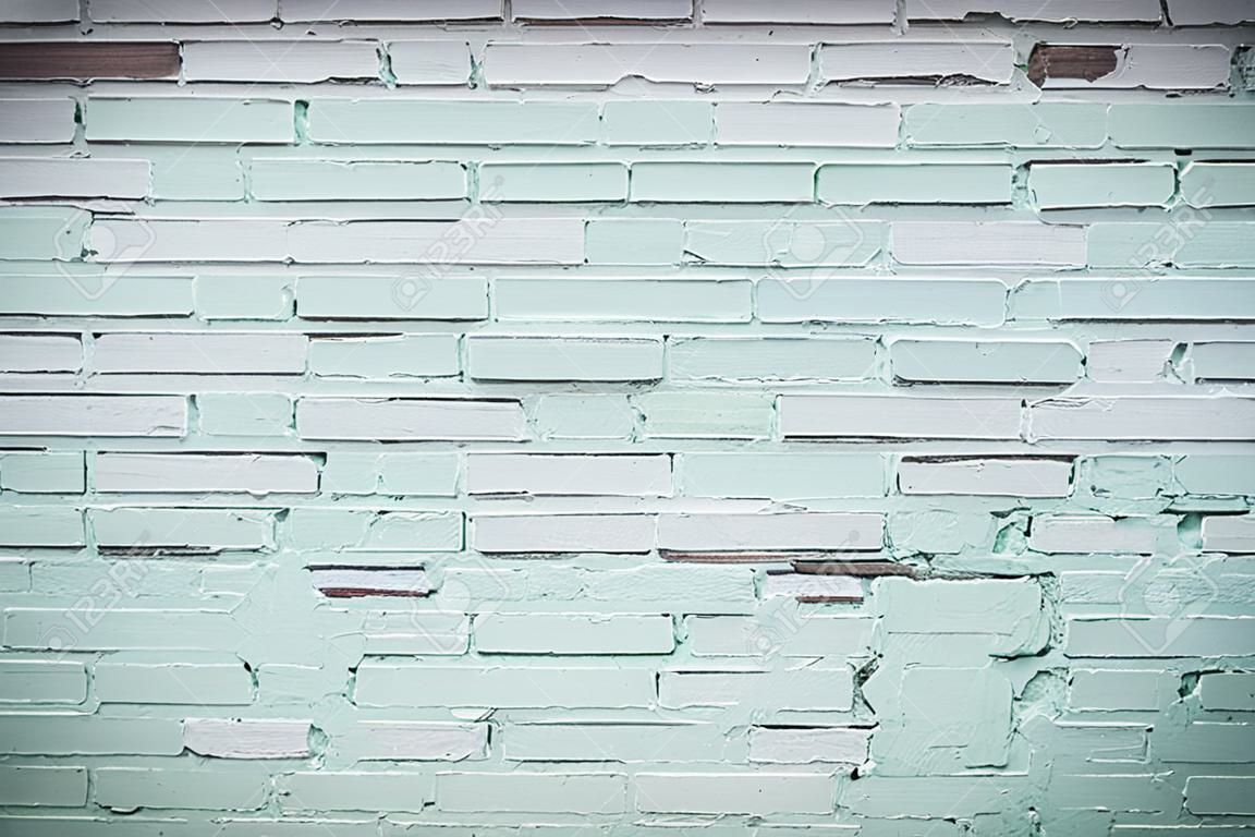 Baksteen muur geschilderd met lichtgroene verf. Achtergrond met bakstenen textuur.