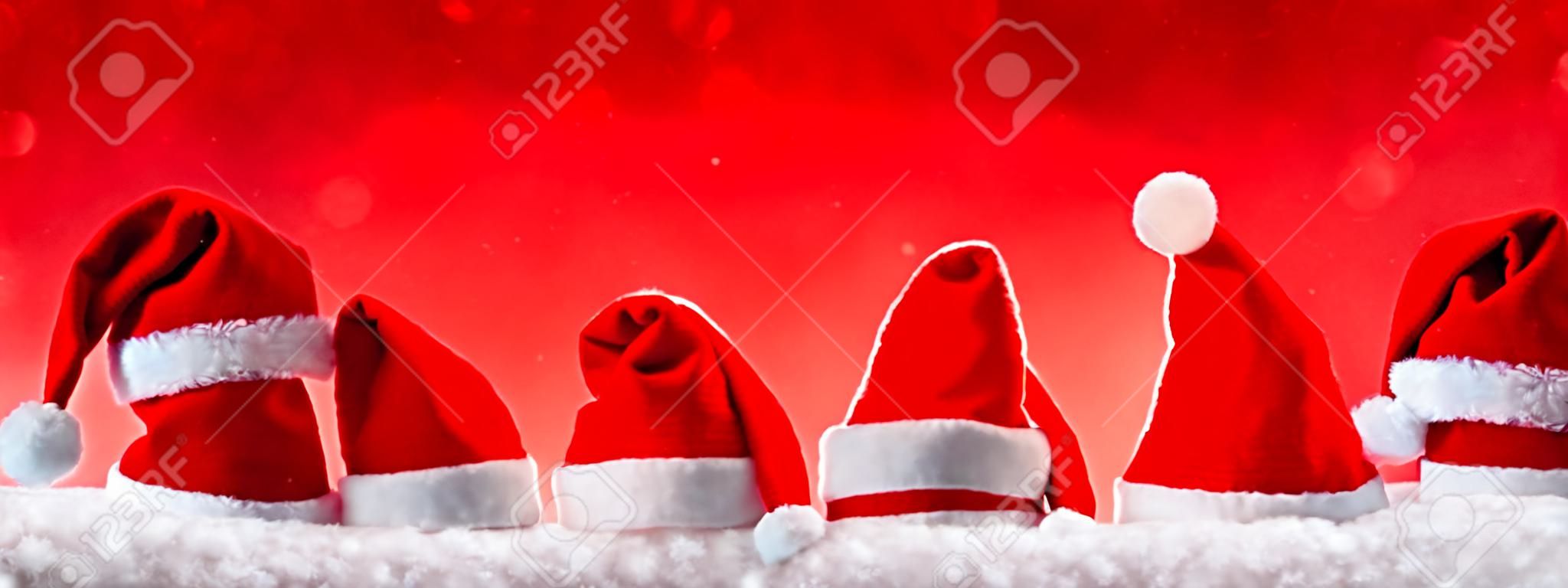 Sept rouge de Père Noël chapeaux isolés sur background.Christmas rouges sur fond rouge avec de Noël hats.Red chapeaux de Noël.