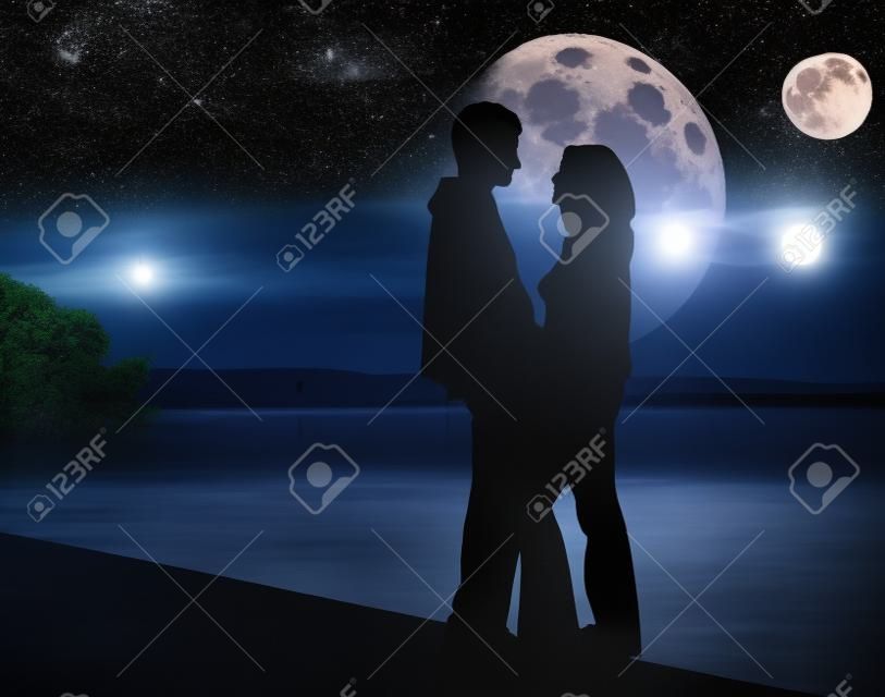 Paire romantique et de la lune énorme derrière