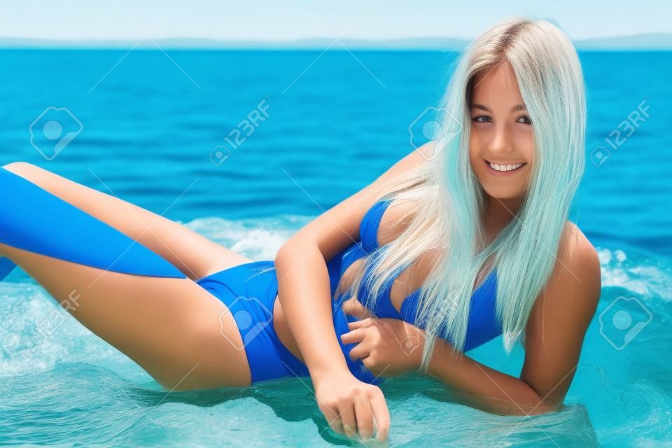 Teenager, girl in blue swimming suit on the beach