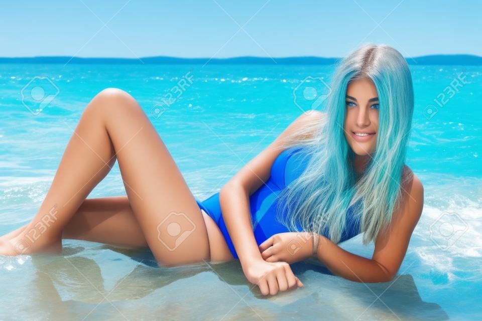 Teenager-Alter, Mädchen im blauen Schwimmenklage am Strand