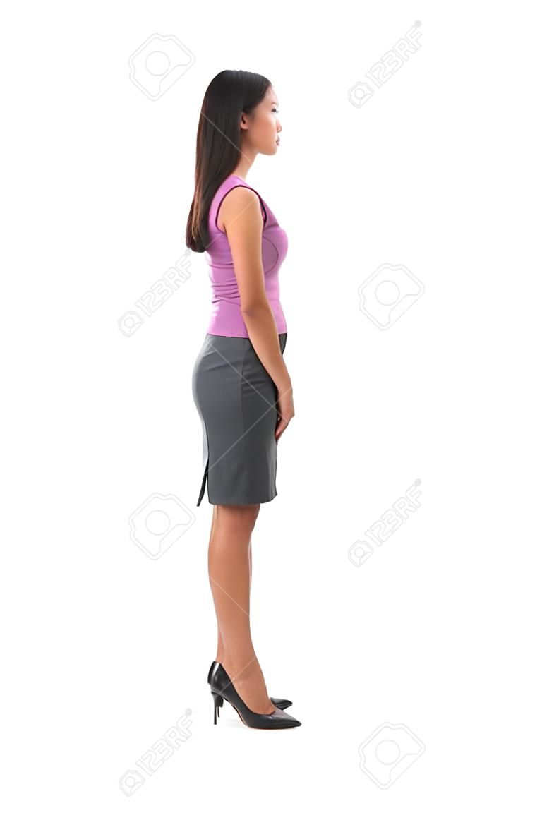 Side view full body of Asian female in office attire standing over white background