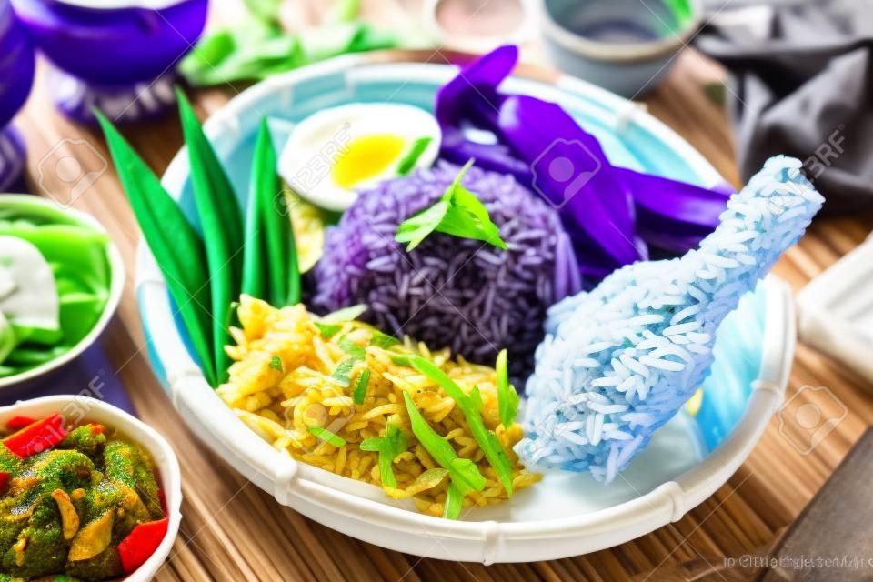 Nasi kerabu ou nasi Ulam, prato de arroz malaio popular. Cor azul do arroz resultante das pétalas de flores de pera-borboleta. Comida tradicional da Malásia, cozinha asiática.