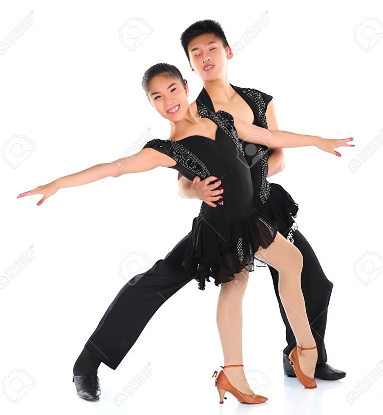 Young Asian teens couple latin dancers dancing in front of the studio background, full length isolated white.