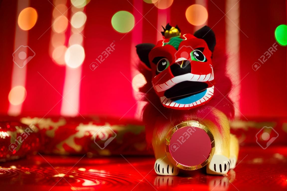 Chinese new year festival decorations, miniature dancing lion on red glitter background.