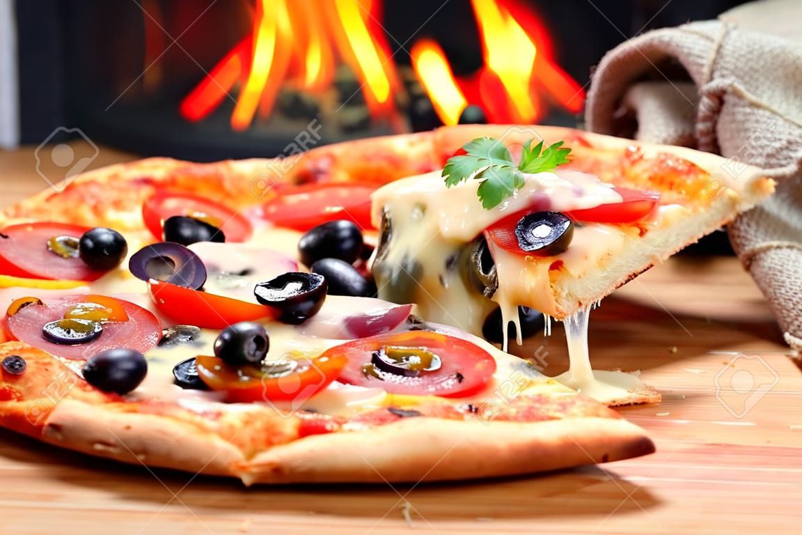Pizza lifting slice with pepperoni and olives
