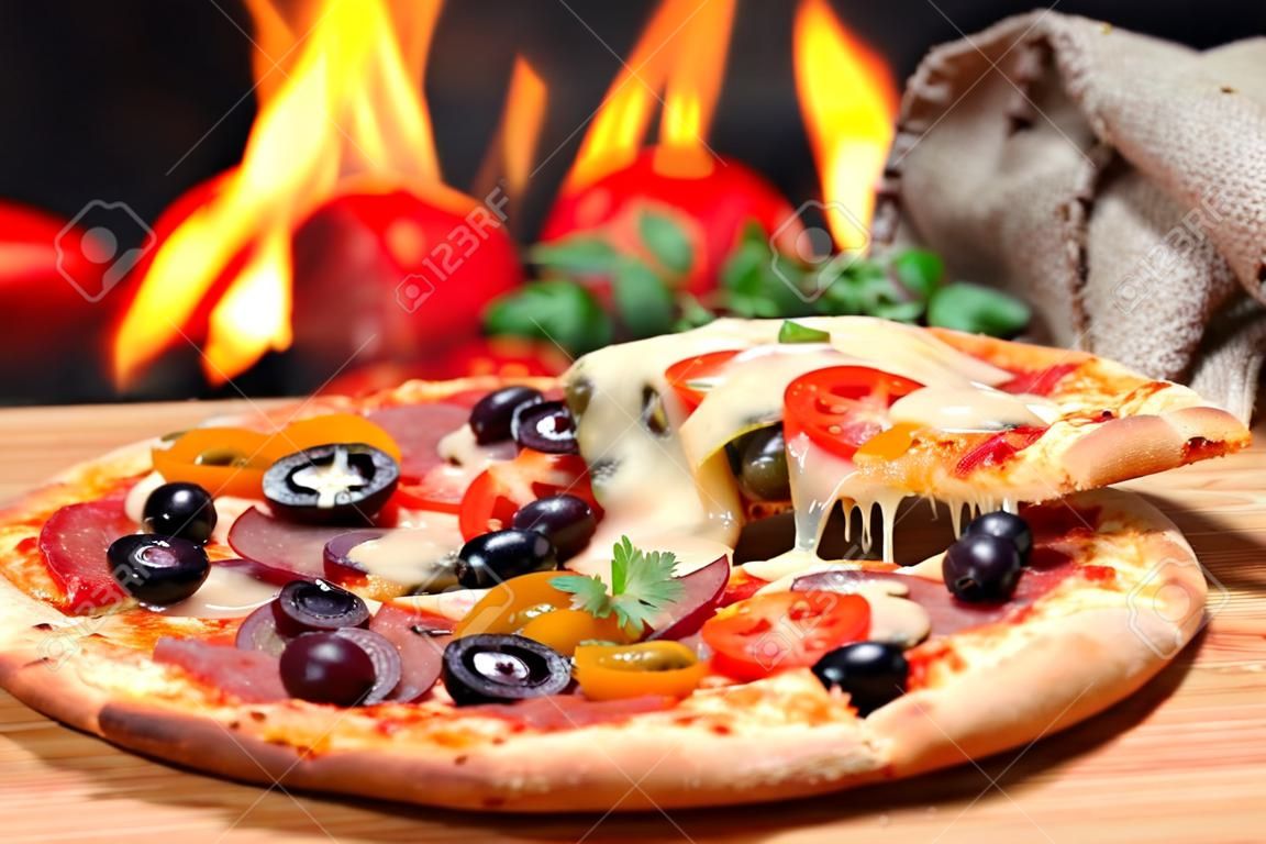 Pizza lifting slice with pepperoni and olives
