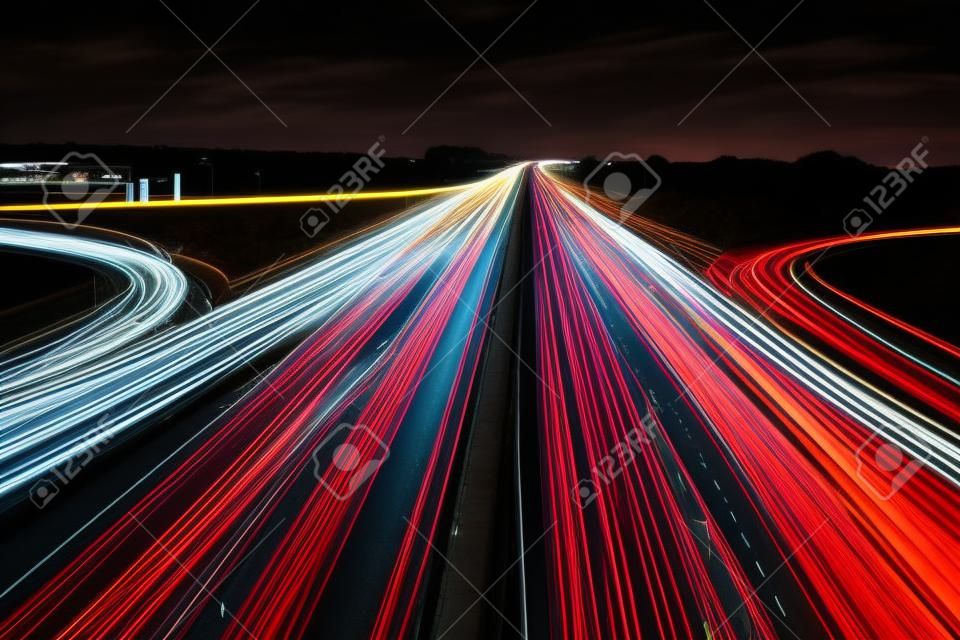 Tráfego de velocidade - trilhas leves na rodovia à noite, fundo urbano abstrato de longa exposição