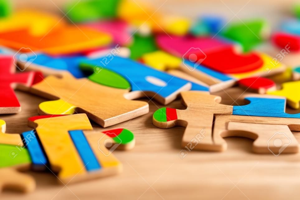 Children's puzzle scattered on a wooden table close up