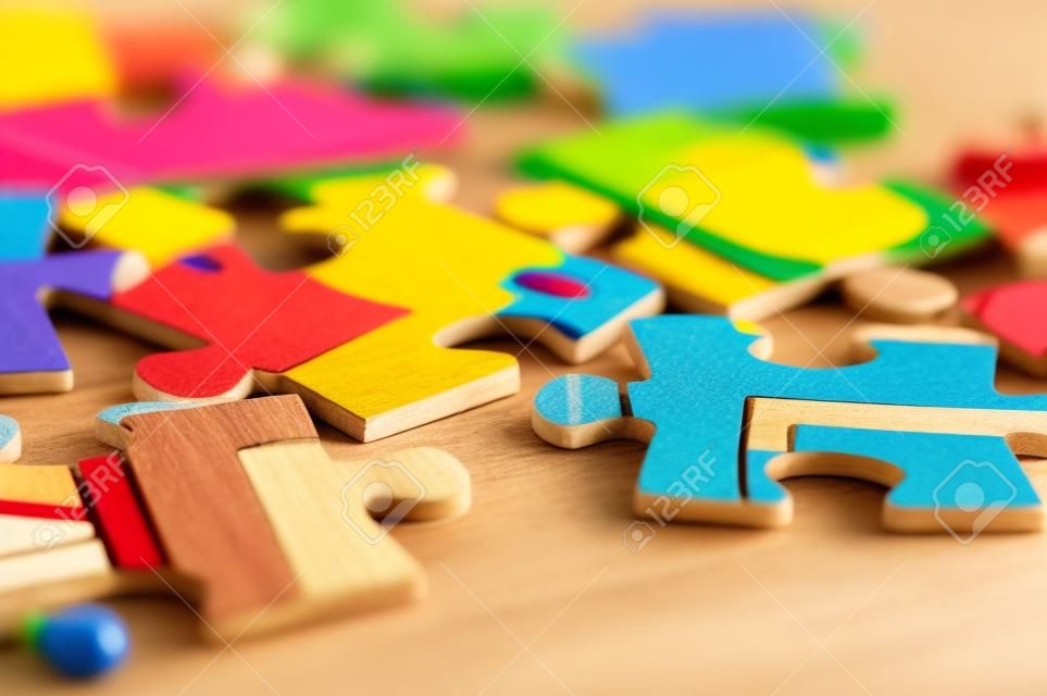 Children's puzzle scattered on a wooden table close up
