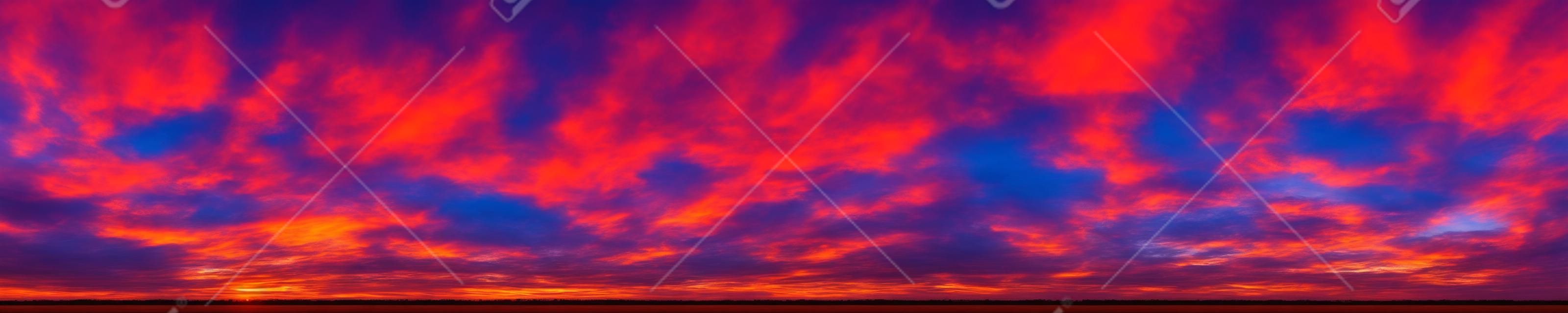 日の出と日の入りの美しい雲と劇的な鮮やかな色のパノラマ。パノラマ画像。