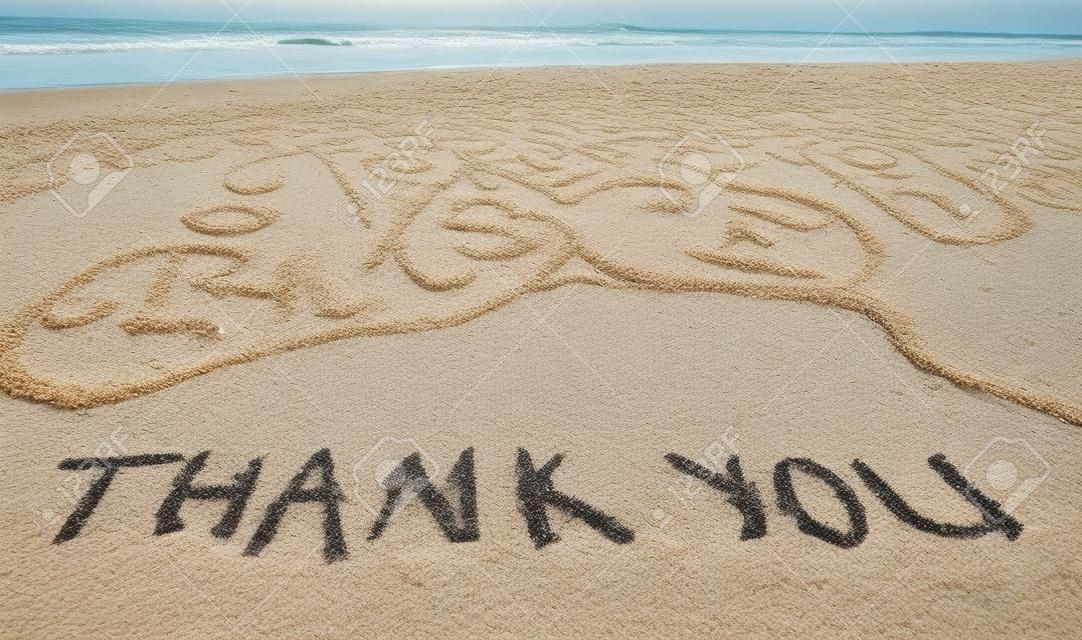 merci mots écrits sur le sable de la plage