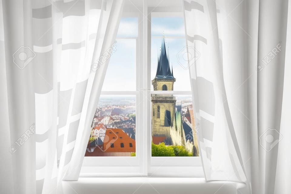 Klassisches weißes Holzfenster mit Vorhängen und Blick auf Prag