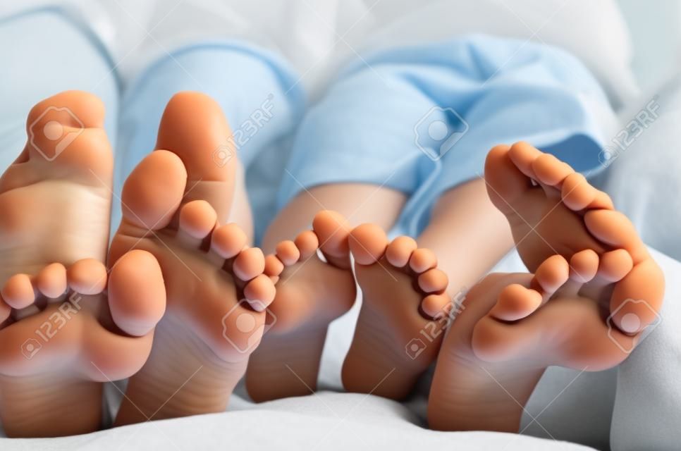 Pieds enfants au lit close-up horizontale