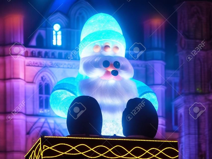 Illuminated Big Santa on town hall at Christmas Market by night on Albert Square in Manchester, England, UK