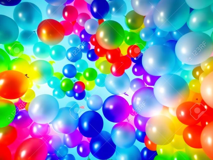 Bright abstract background of jumble of rainbow colored balloons celebrating.