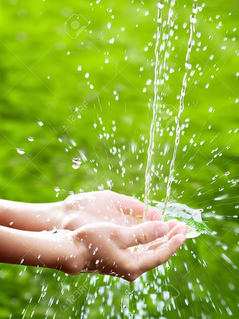 Stream z czystą wodą wlewając do rąk dzieci.