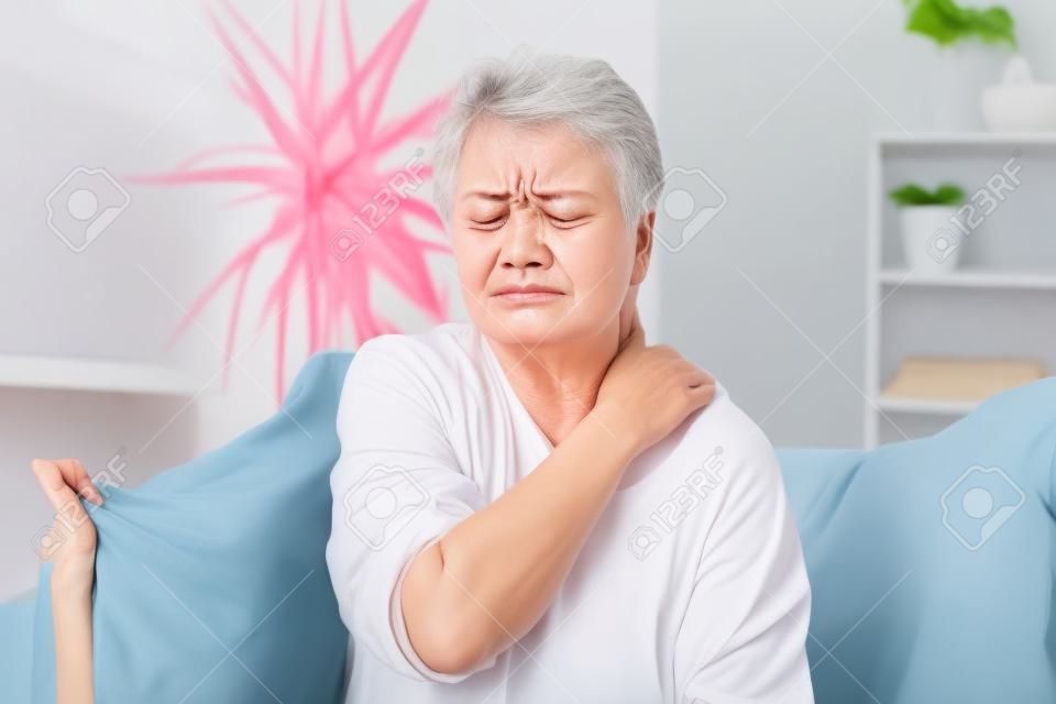 Infeliz 60 anos de idade mulher massageando pescoço em casa, sofrendo de dor severa nas costas. sensação feminina sênior mal-estar nos músculos cansados, conceito de problema de saúde