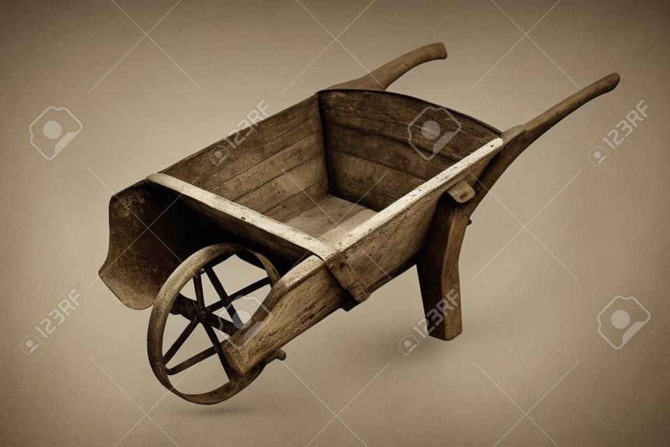 historic hamdmade wheelbarrow isolated over white background; thie is a rare barrow made of wood