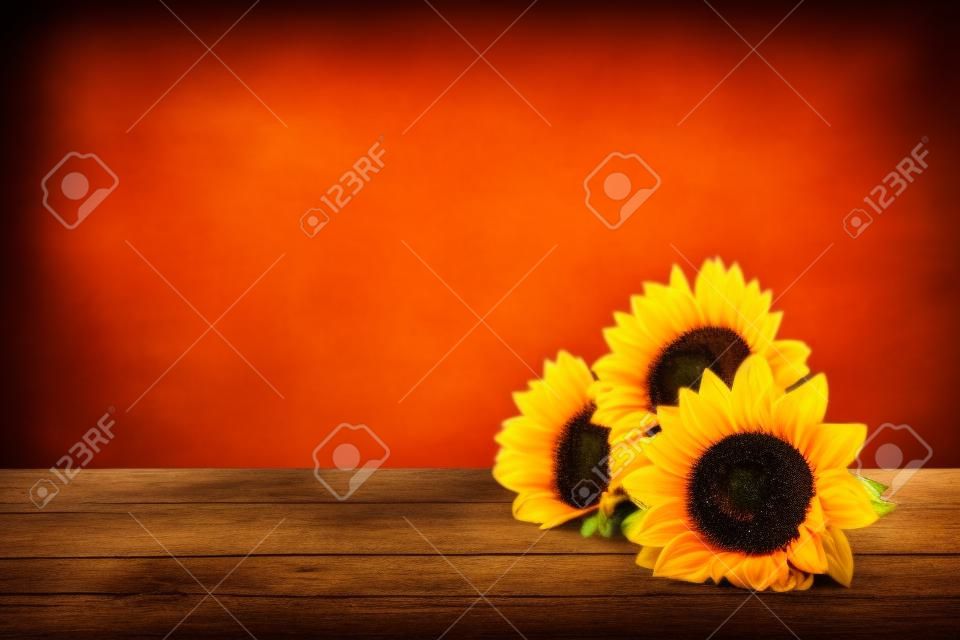 Beautiful sunflowers laying on a wooden table with vintage background
