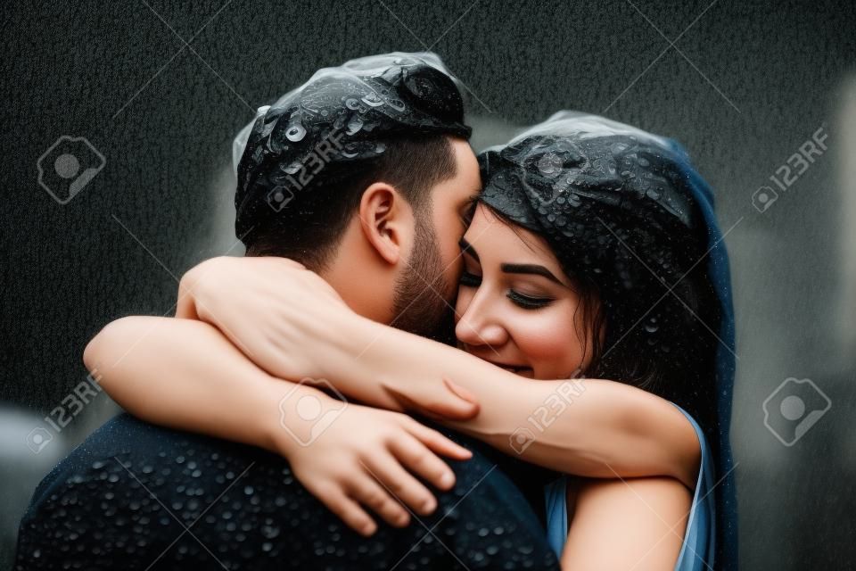 beautiful couple hugging on outside in the rain