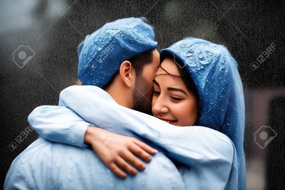 mooi paar knuffelen op buiten in de regen