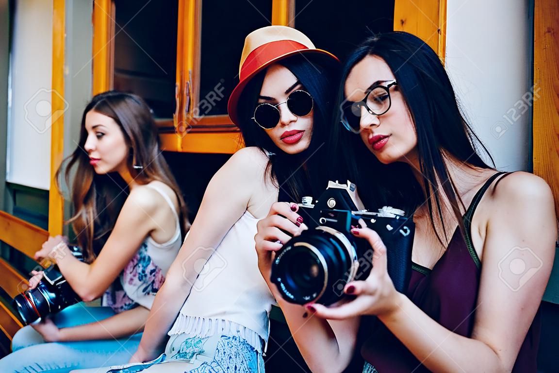 Duas meninas bonitas jovens estão segurando a câmera vintage