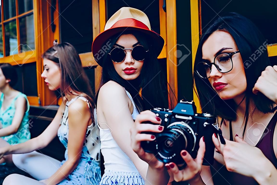 Duas meninas bonitas jovens estão segurando a câmera vintage